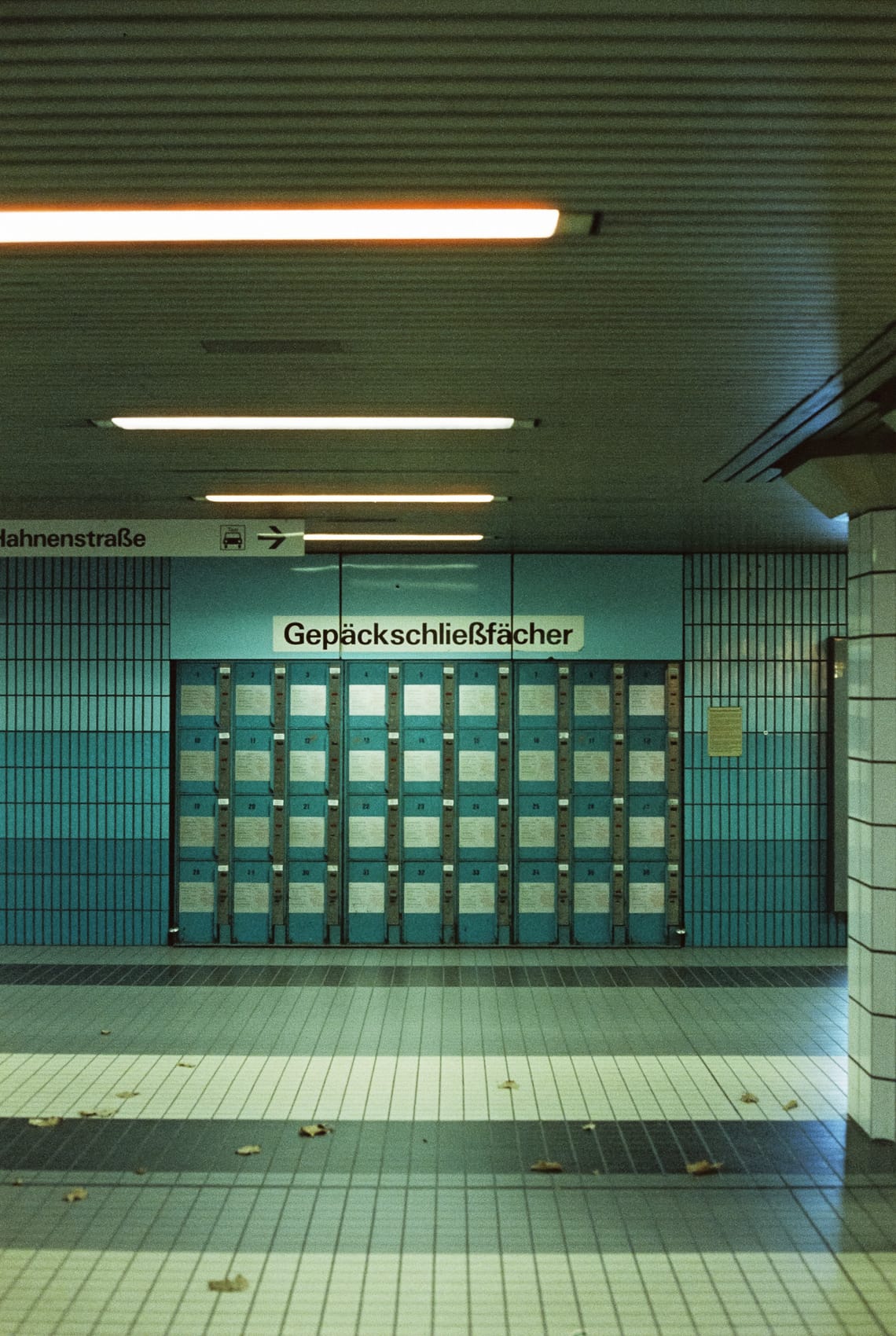 A wall of luggage lockers in a subway photographed on analog film.